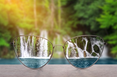 Image of Glasses against beautiful landscape. View through lenses more clear. Vision correction