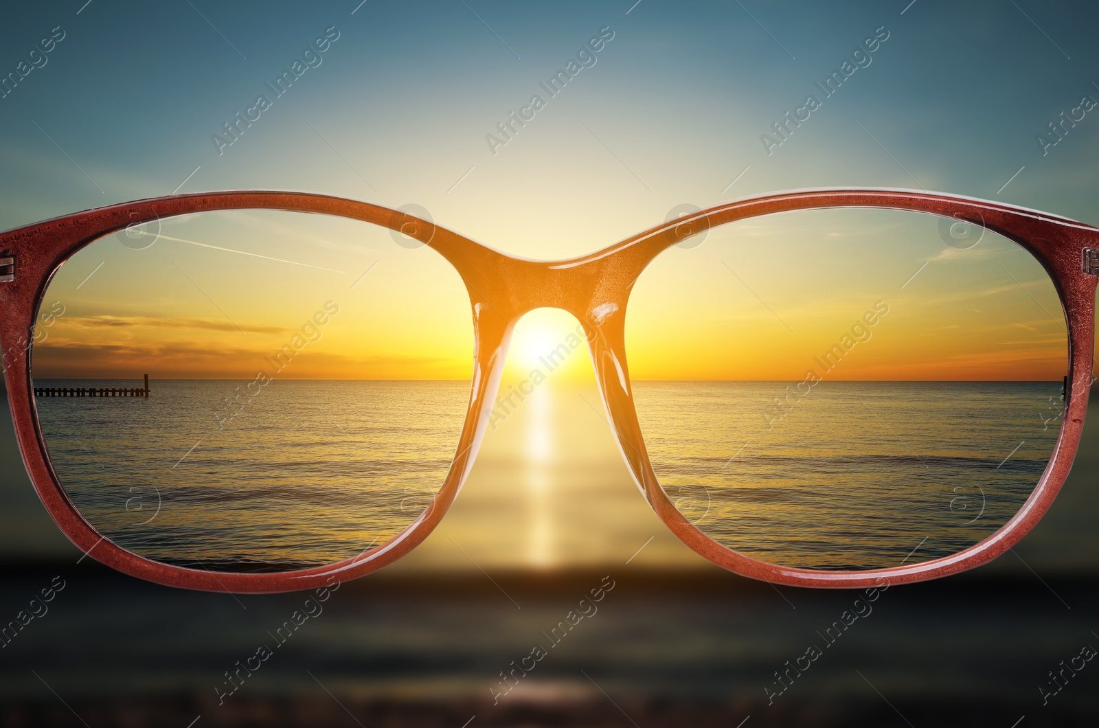 Image of Glasses against beautiful seascape. View through lenses more clear. Vision correction