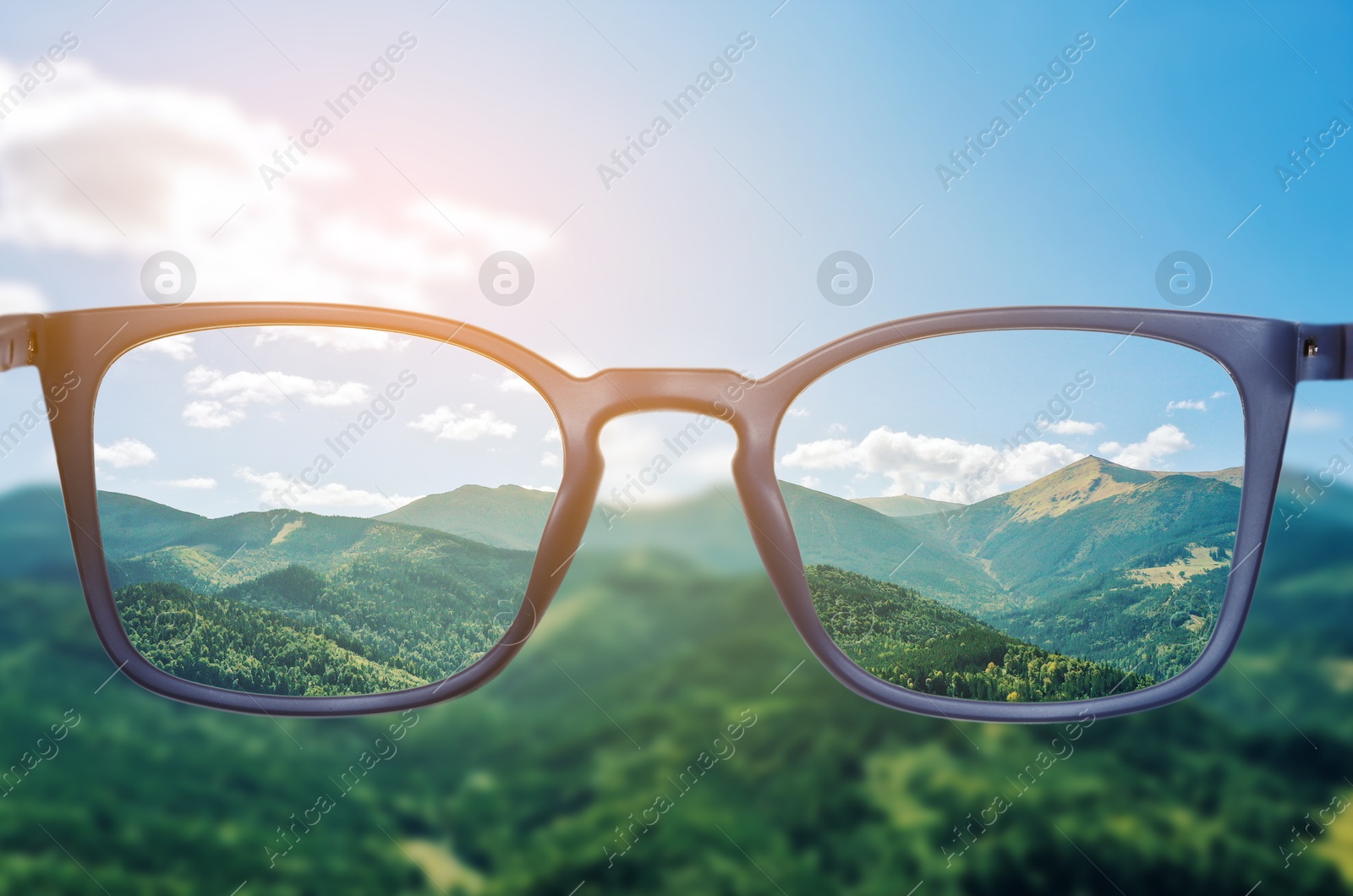 Image of Glasses against beautiful mountain landscape. View through lenses more clear. Vision correction