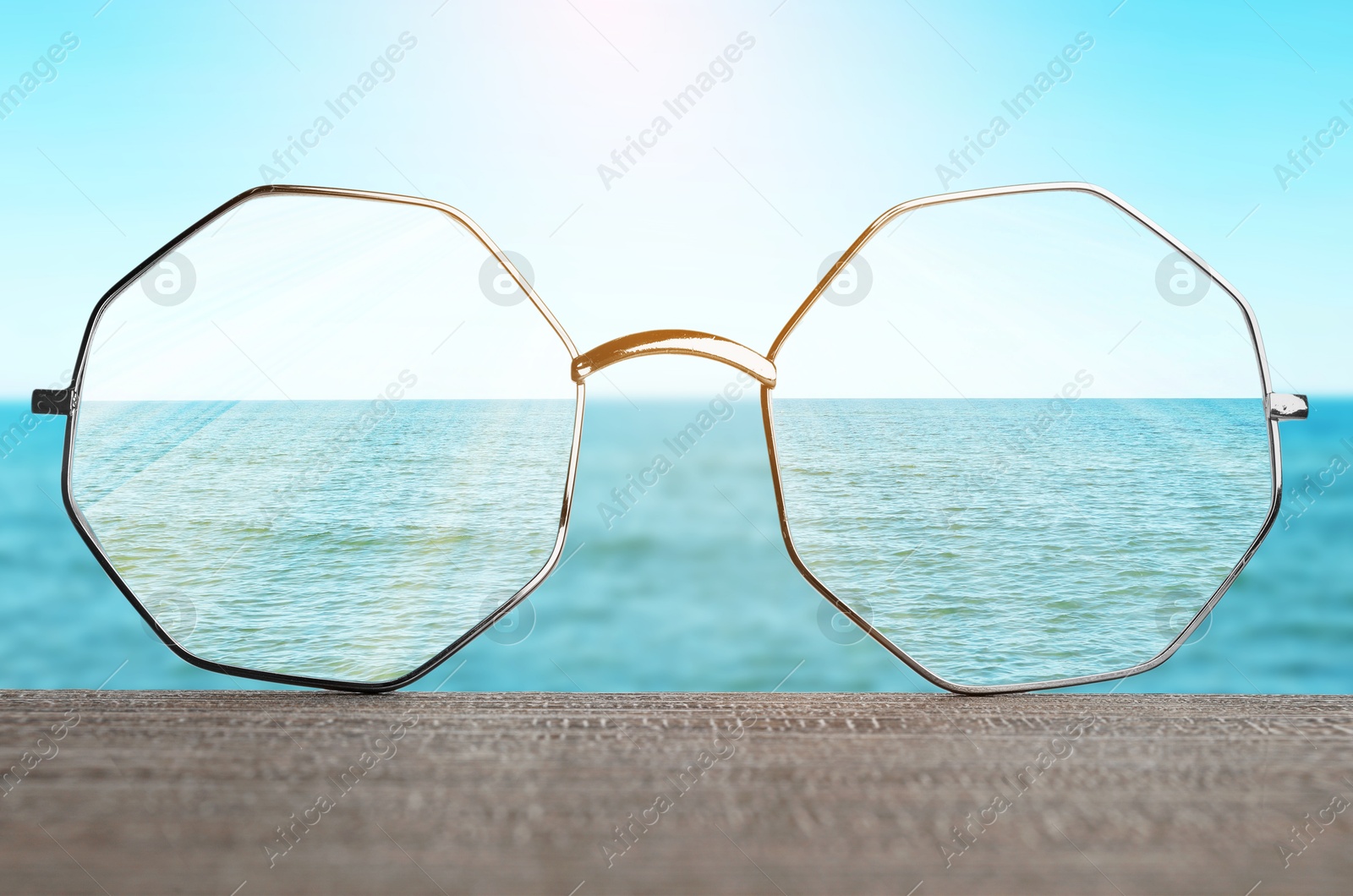 Image of Glasses against beautiful seascape. View through lenses more clear. Vision correction