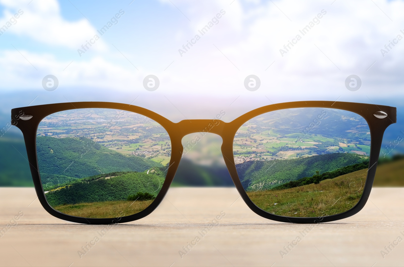 Image of Glasses against beautiful landscape. View through lenses more clear. Vision correction