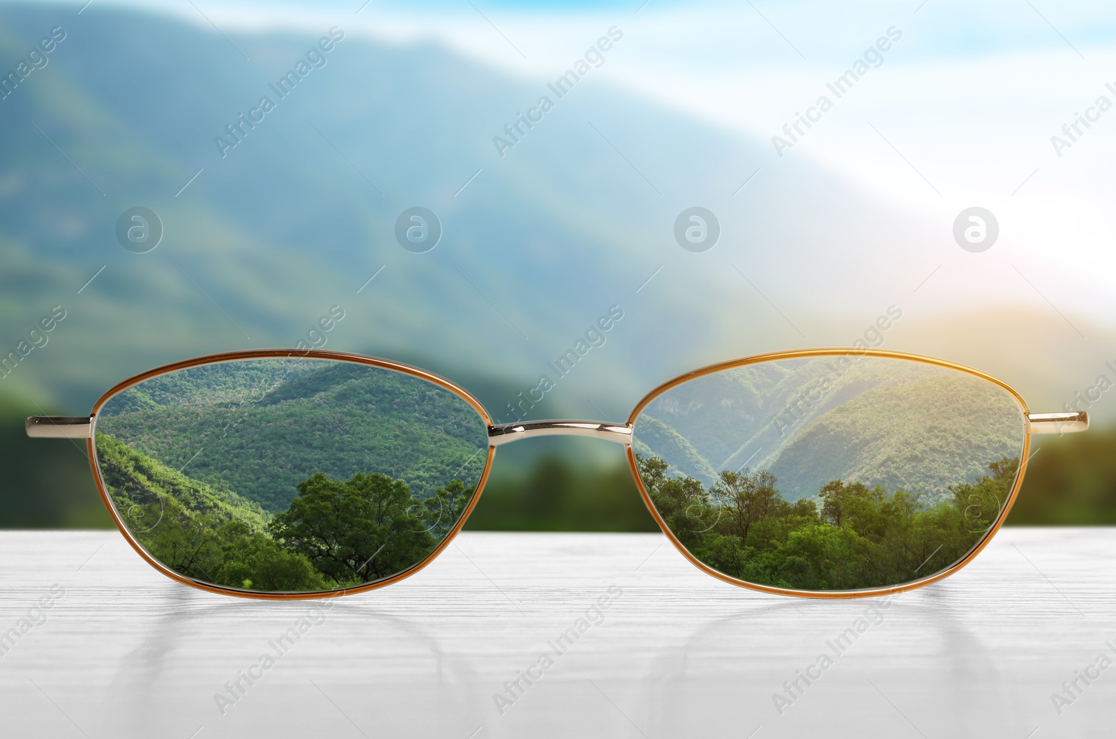 Image of Glasses against beautiful landscape. View through lenses more clear. Vision correction