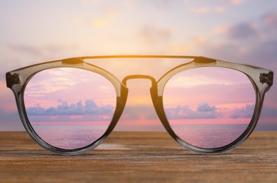 Image of Glasses against beautiful seascape. View through lenses more clear. Vision correction