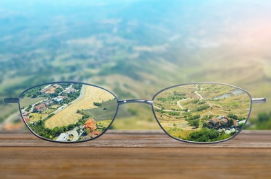 Image of Glasses against beautiful landscape. View through lenses more clear. Vision correction