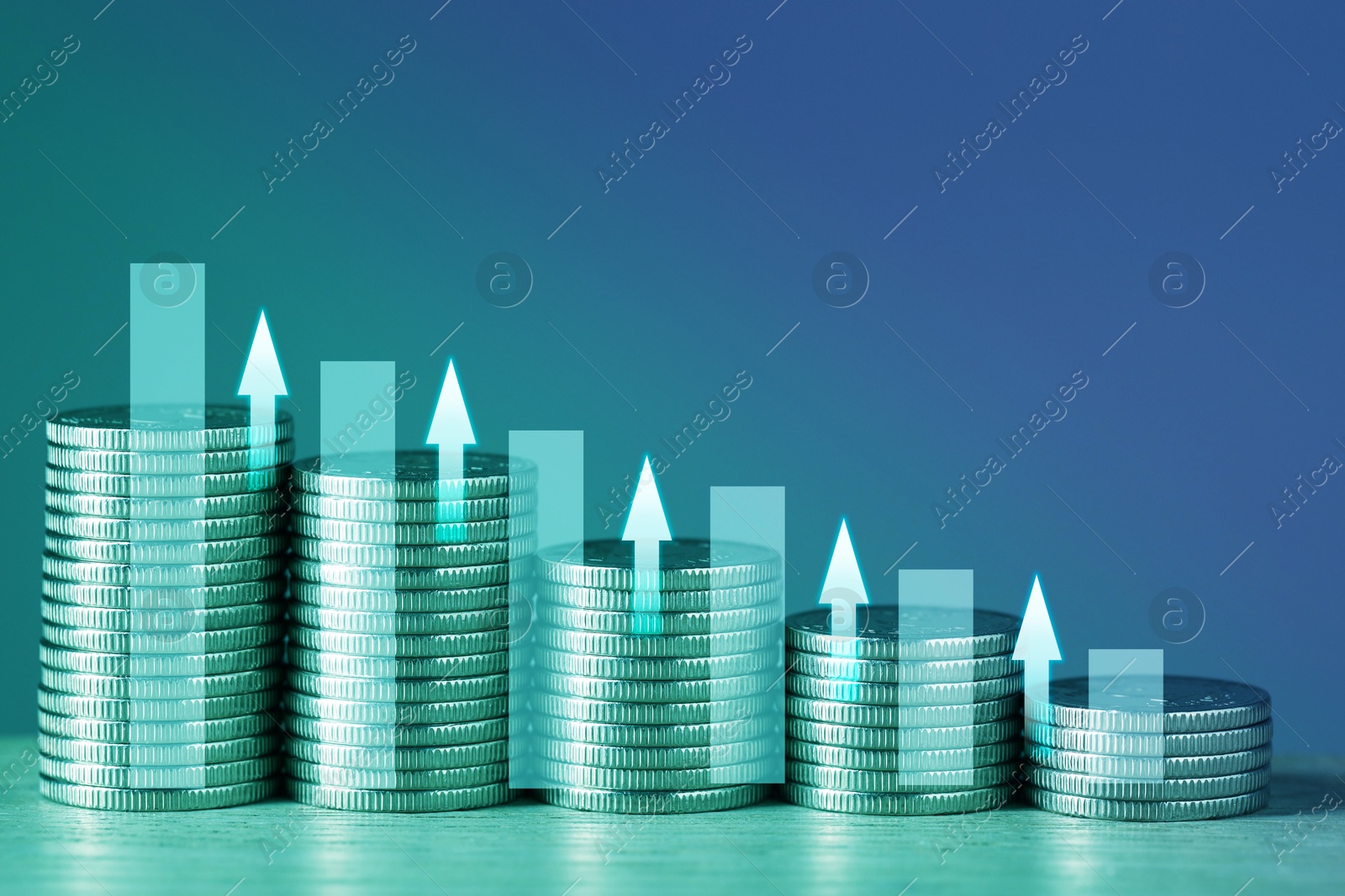 Image of Investment. Stacked coins with arrows on table, color toned