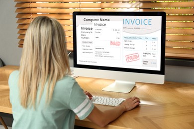 Image of Woman using computer to pay bills at home