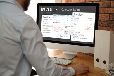 Image of Man using computer to pay bills at home, closeup