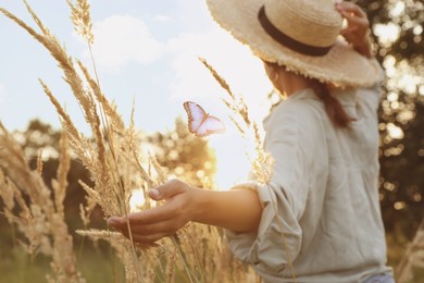 Image of Woman and butterfly in field at sunrise. Health, spring, freedom, beauty