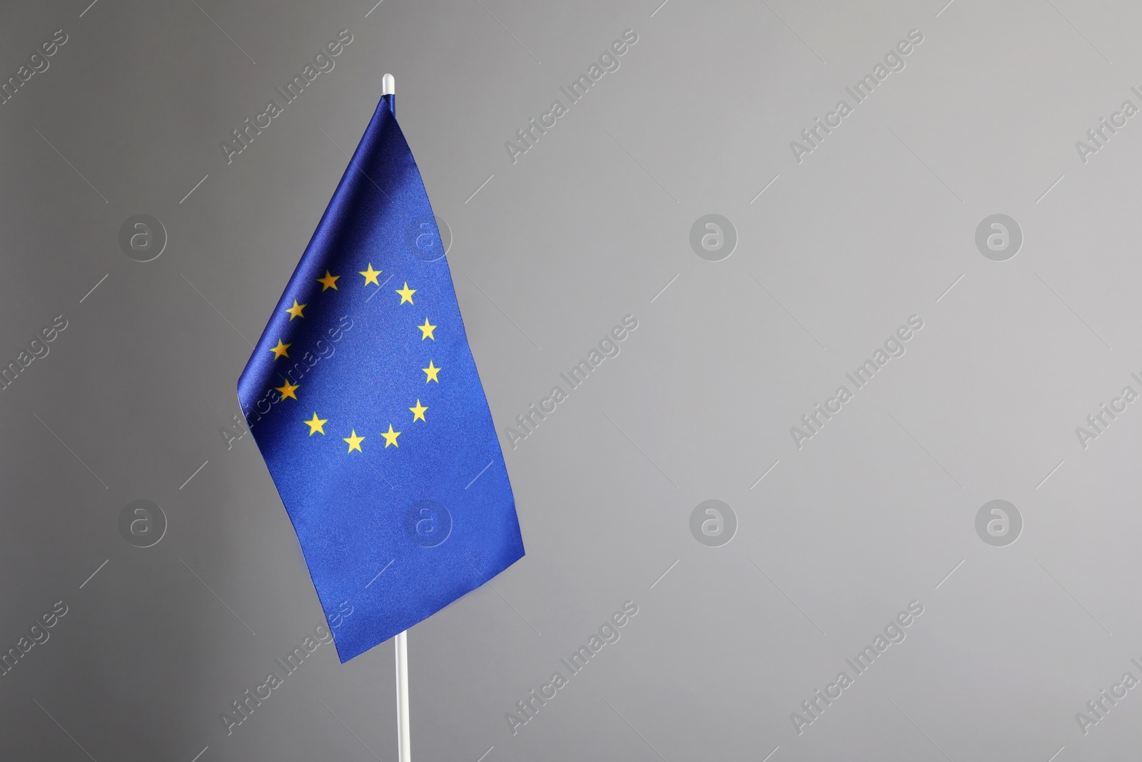 Photo of One flag of European Union on grey background. Space for text