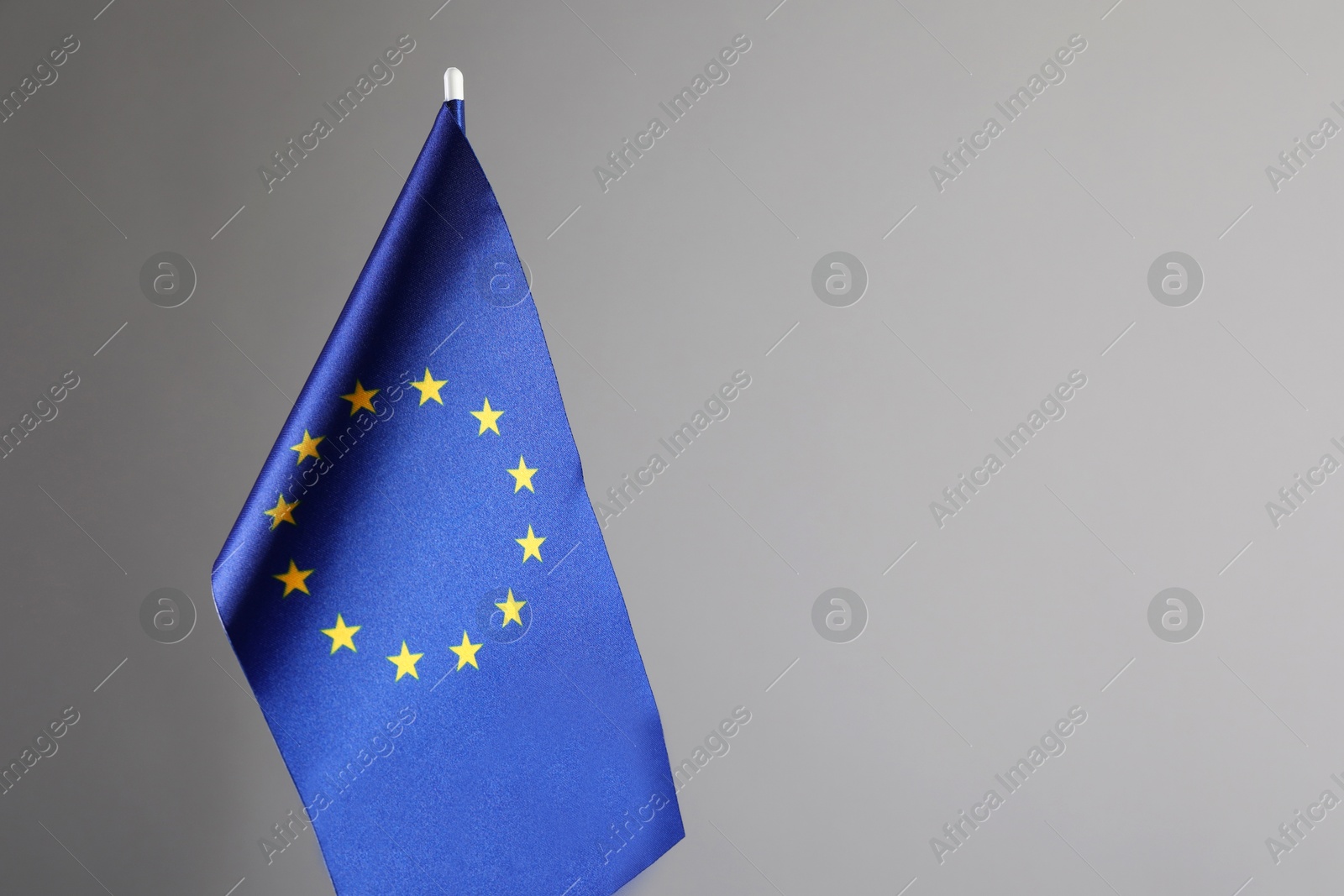 Photo of One flag of European Union on grey background. Space for text