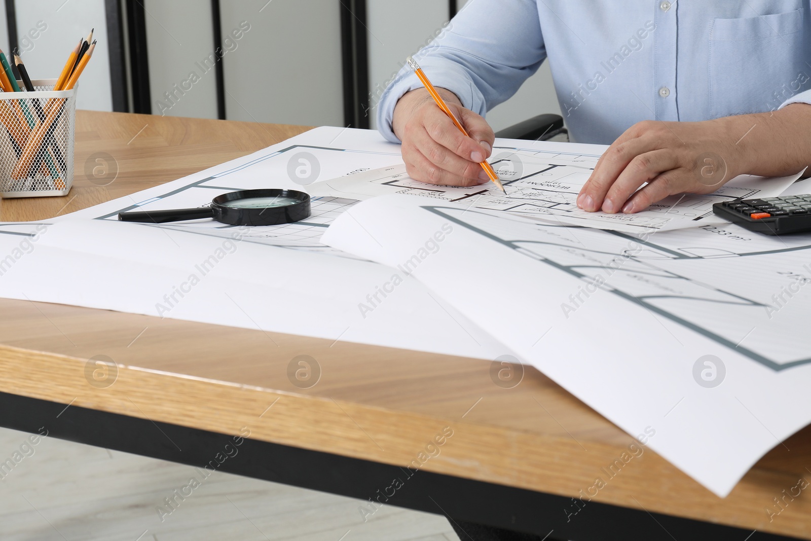 Photo of Architect working with project at wooden table in office, closeup