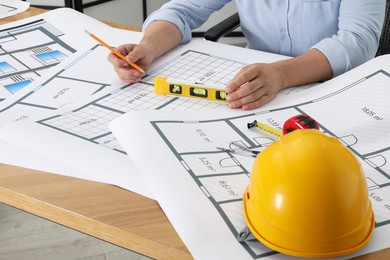 Photo of Architect working with project at wooden table in office, closeup