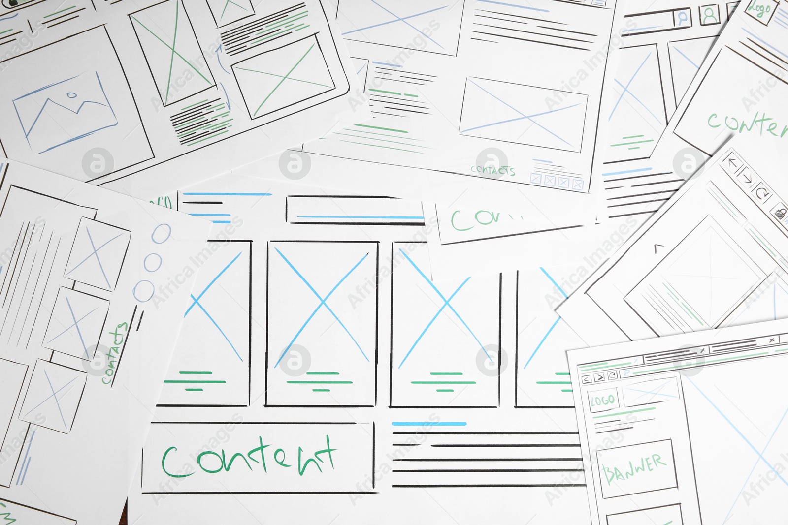 Photo of Developing UI design. Sketches of website wireframes on as background, top view