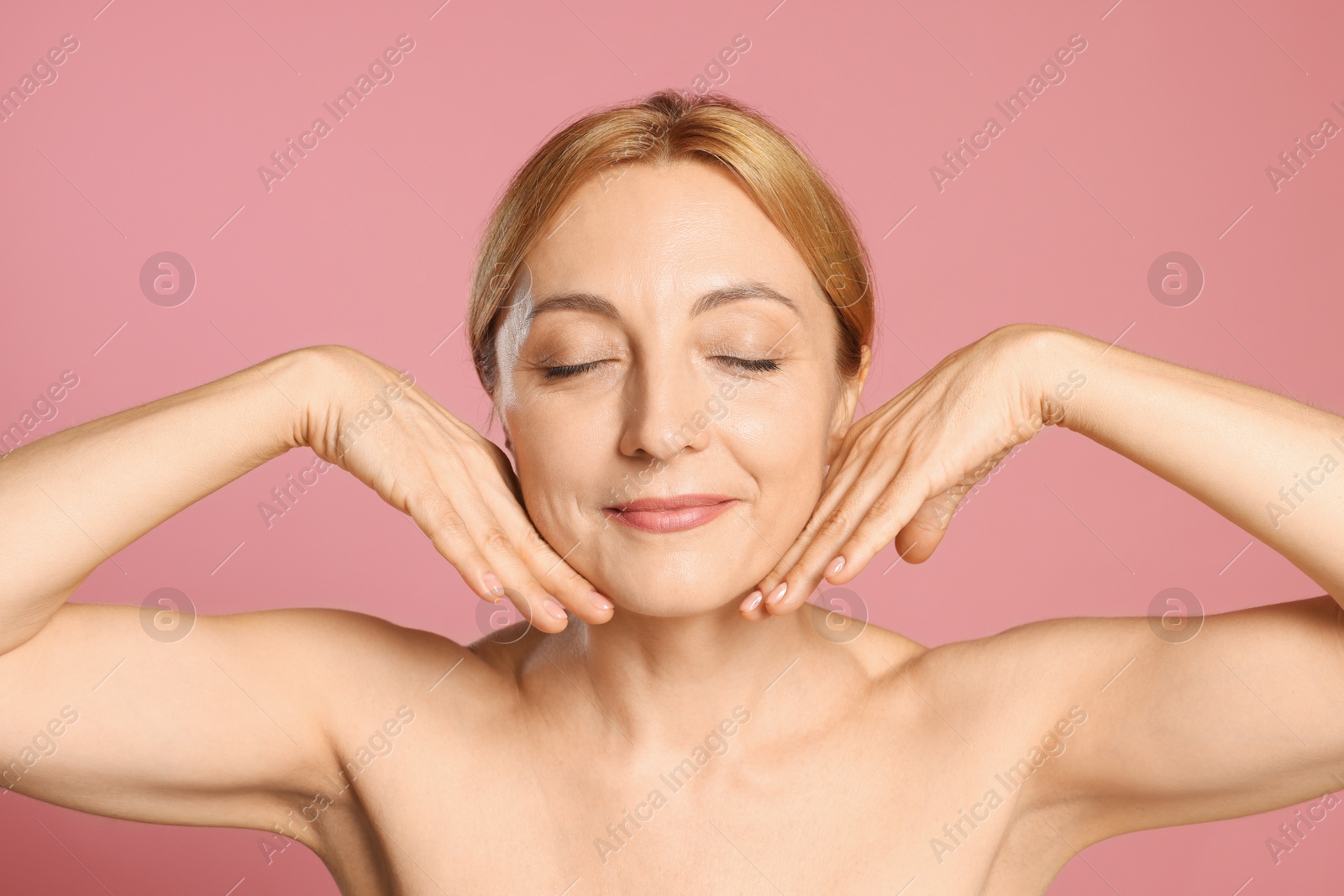 Photo of Portrait of beautiful woman with healthy skin on pink background