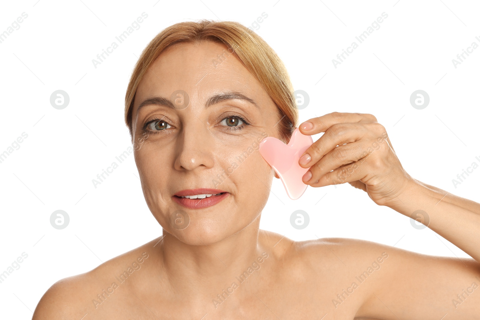 Photo of Smiling woman doing facial self massage with gua sha tool on white background