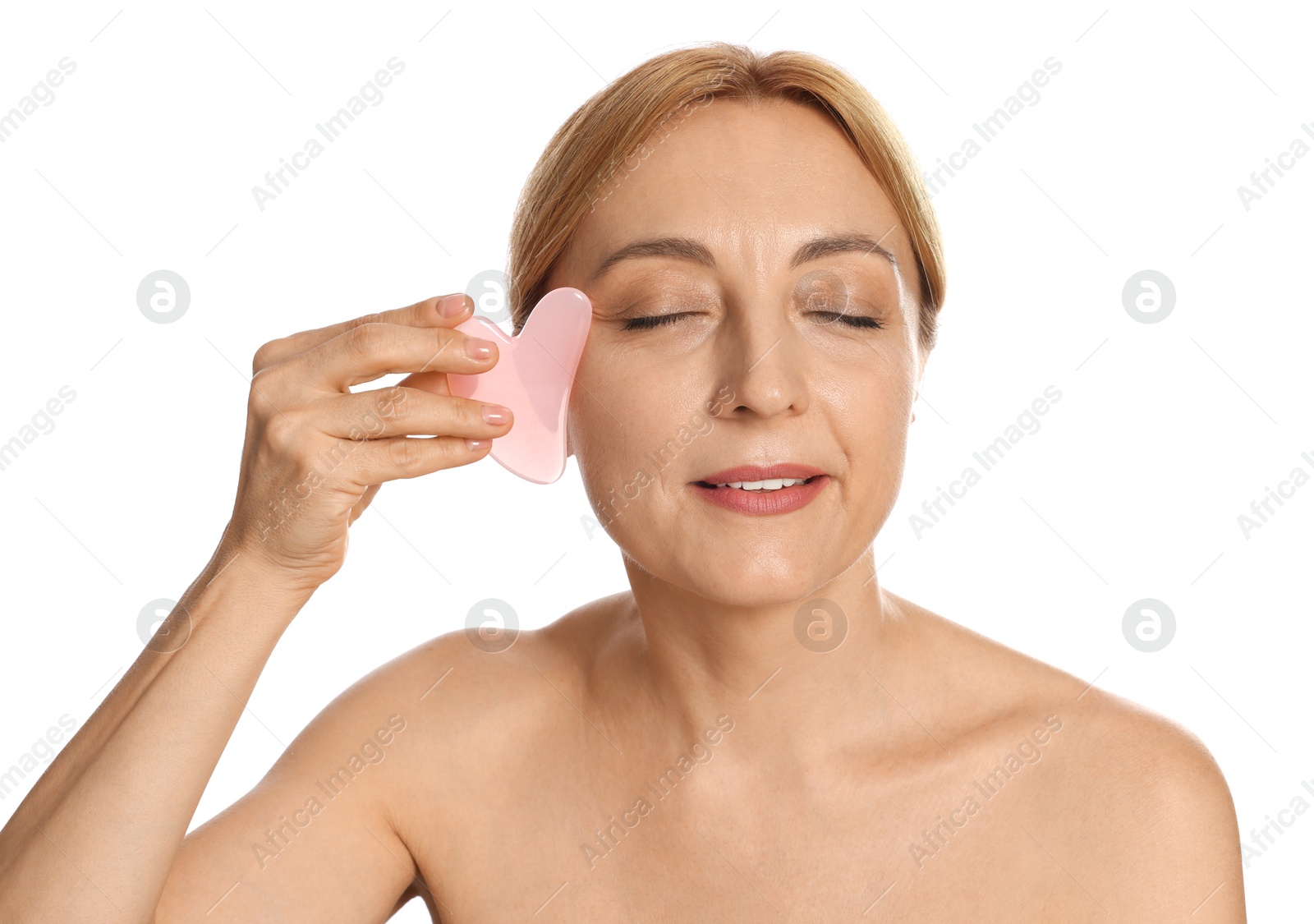 Photo of Smiling woman doing facial self massage with gua sha tool on white background