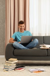 Photo of Student studying with laptop on sofa at home