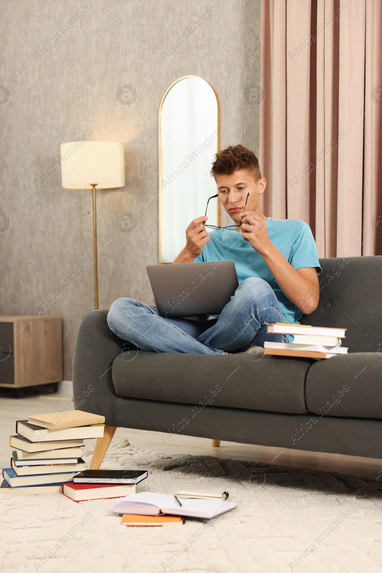 Photo of Student studying with laptop on sofa at home