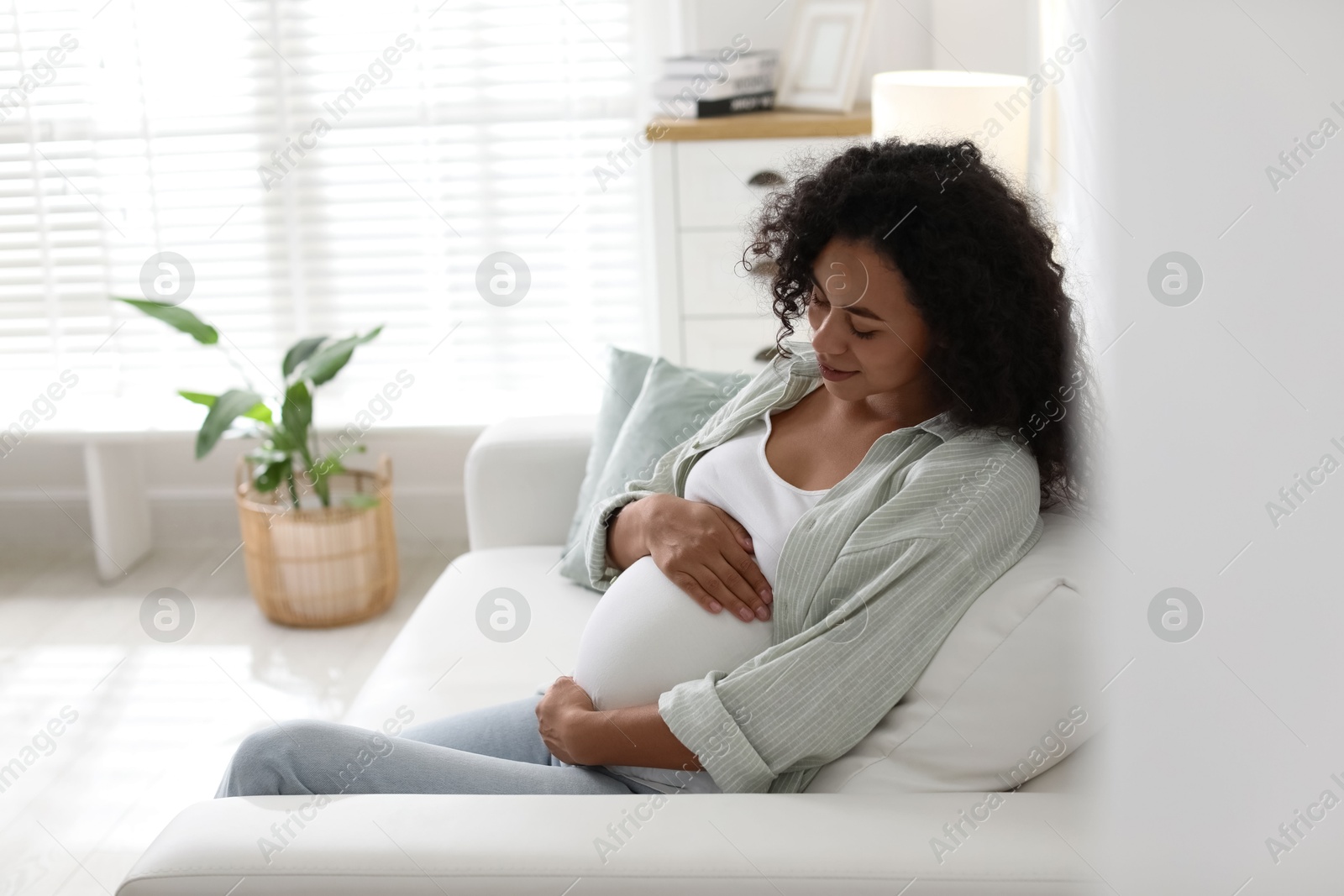 Photo of Portrait of beautiful pregnant woman on sofa at home