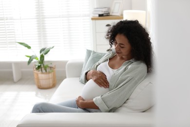 Photo of Portrait of beautiful pregnant woman on sofa at home