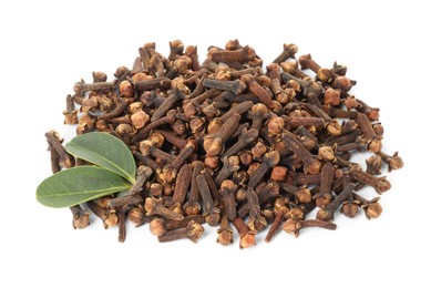 Pile of dry clove buds and green leaves on white background. Aromatic spice