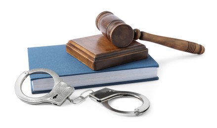 Handcuffs, judge's gavel and book isolated on white