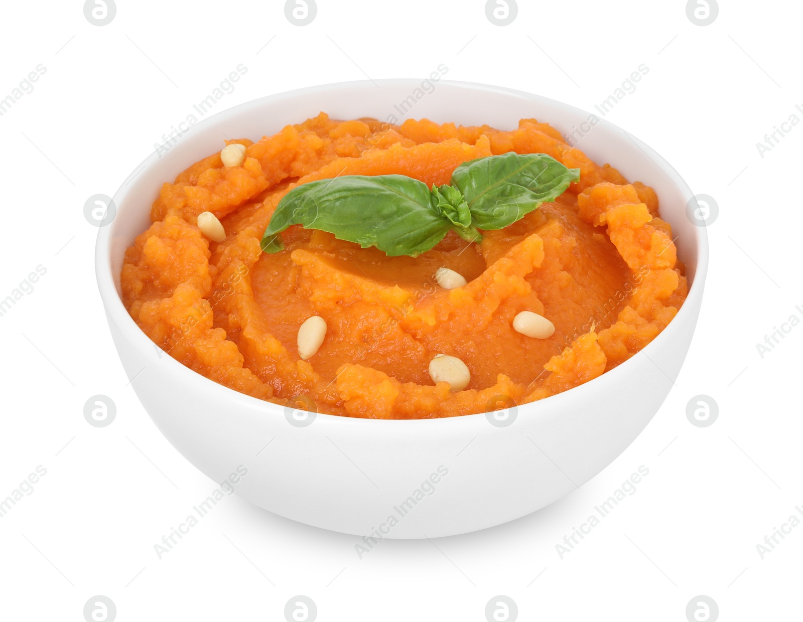 Photo of Tasty mashed sweet potato with basil and seeds in bowl isolated on white