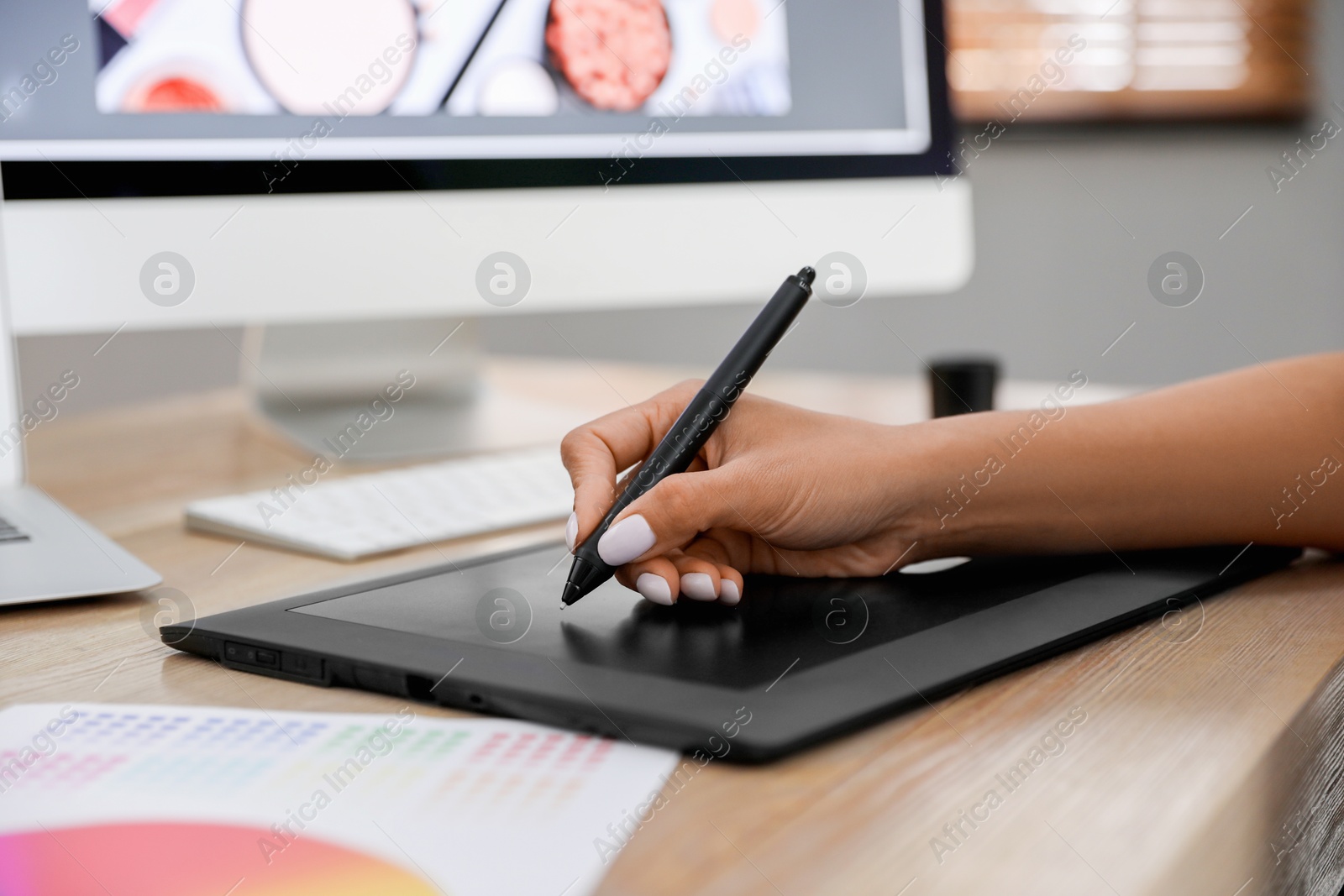 Photo of Professional retoucher working on graphic tablet at table, closeup