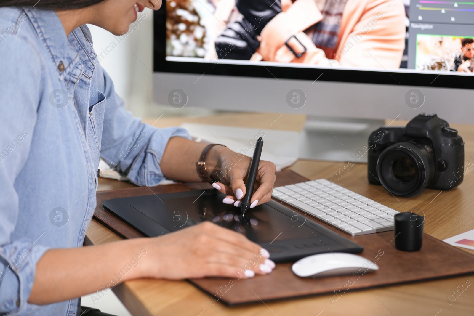 Photo of Professional retoucher working on graphic tablet at table, closeup