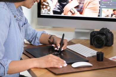 Photo of Professional retoucher working on graphic tablet at table, closeup