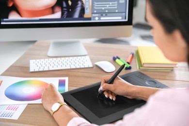 Photo of Professional retoucher working on graphic tablet at table, closeup