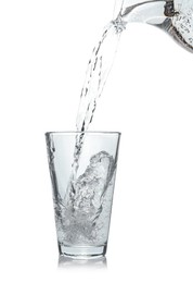 Pouring soda water from jug into glass on white background