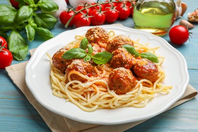 Delicious pasta with meatballs and ingredients on light blue wooden table, closeup