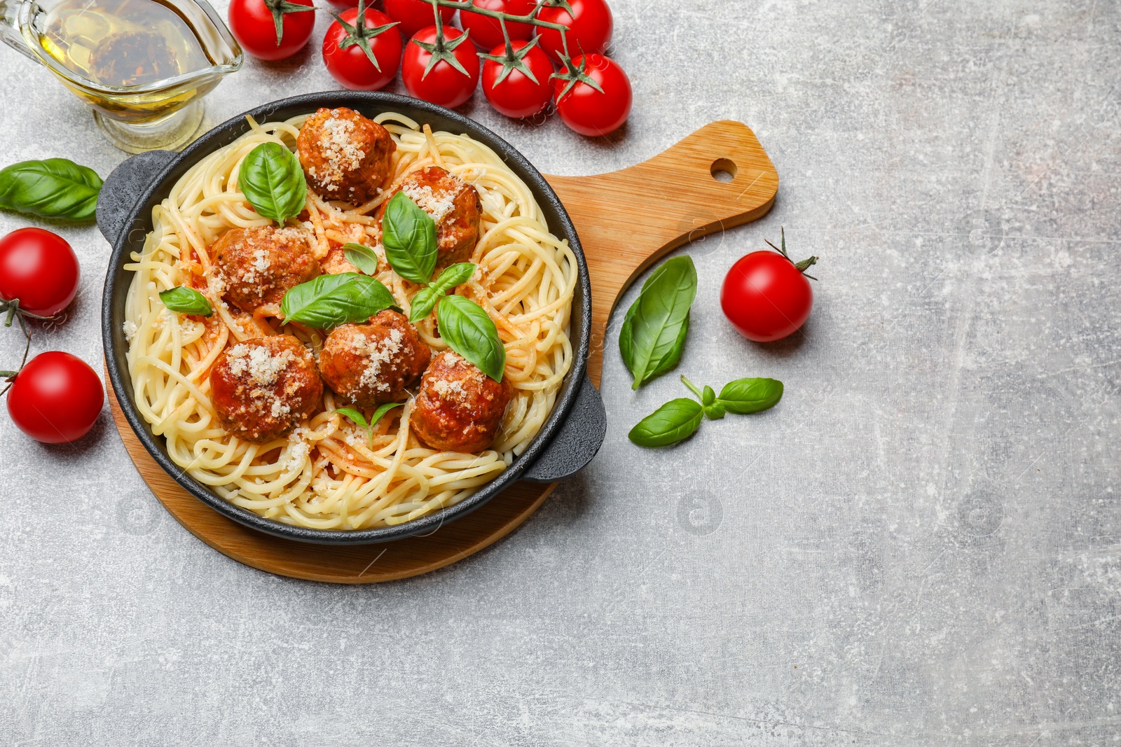 Photo of Delicious pasta with meatballs and ingredients on light grey table, flat lay. Space for text