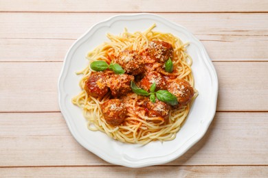 Delicious pasta with meatballs on light wooden table, top view