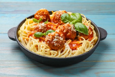 Photo of Delicious pasta with meatballs on light blue wooden table, closeup