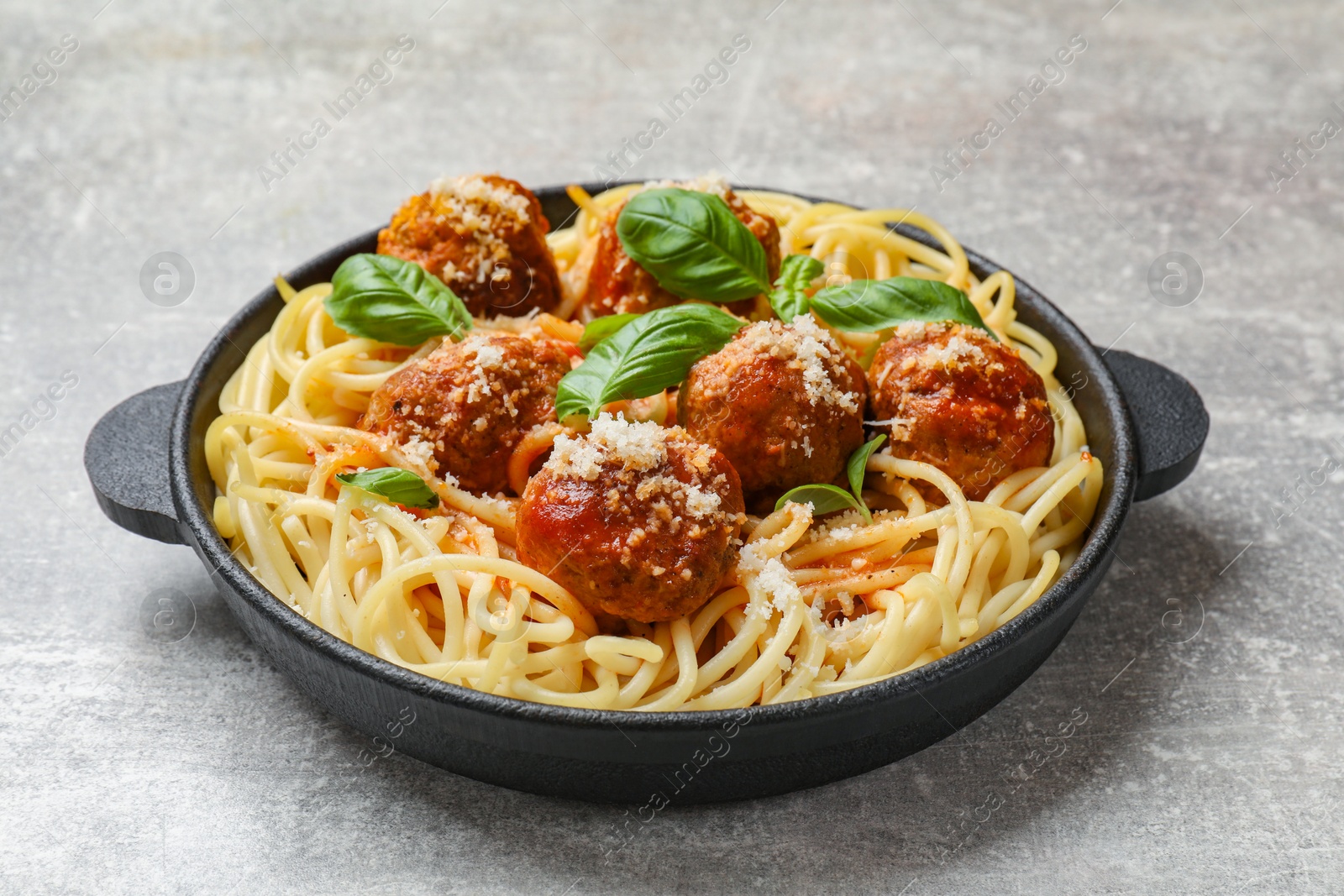 Photo of Delicious pasta with meatballs on light grey table, closeup