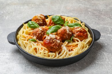 Delicious pasta with meatballs on light grey table, closeup