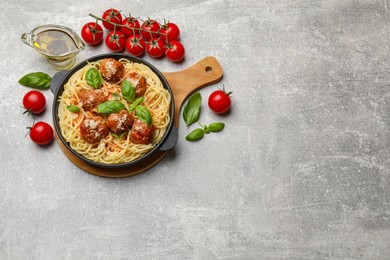 Photo of Delicious pasta with meatballs and ingredients on light grey table, flat lay. Space for text