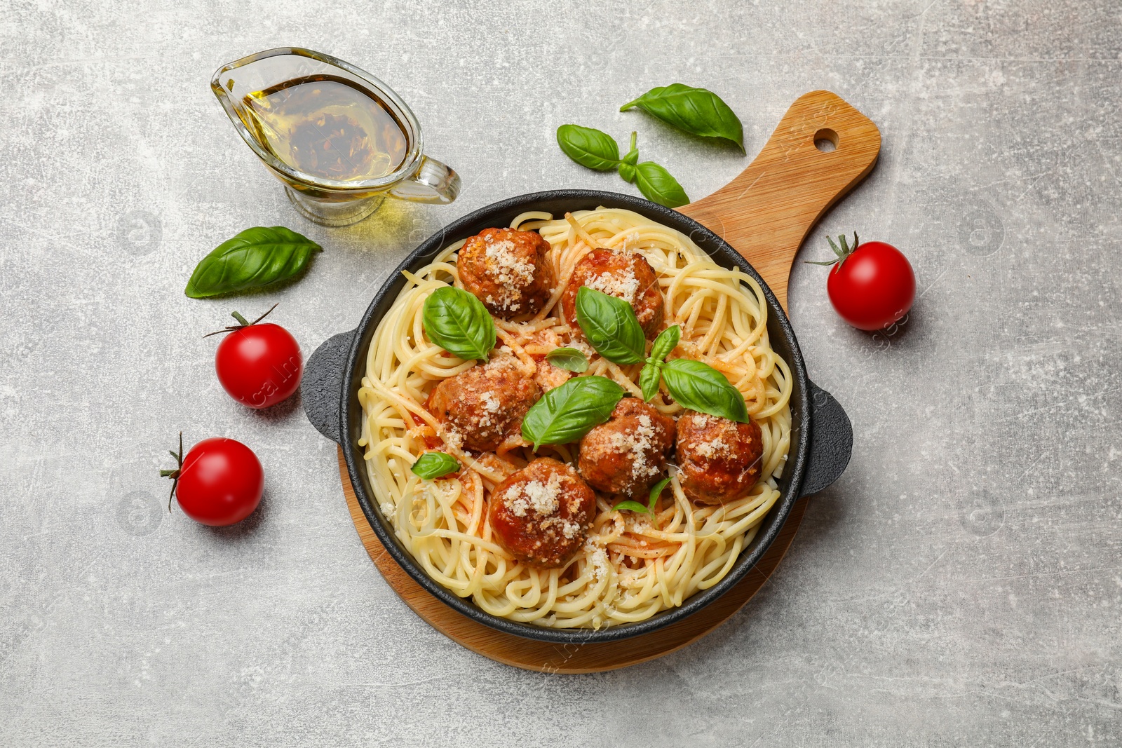 Photo of Delicious pasta with meatballs and ingredients on light grey table, flat lay