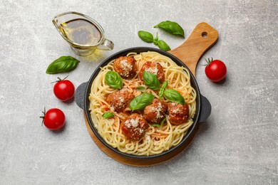 Delicious pasta with meatballs and ingredients on light grey table, flat lay