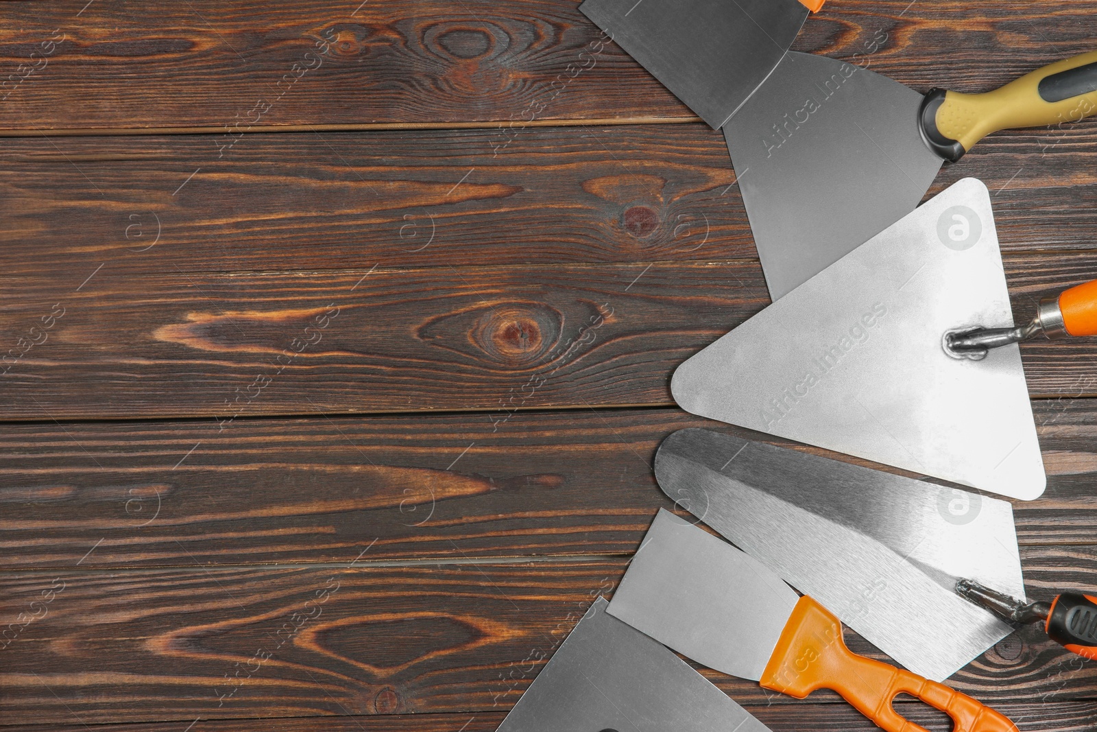 Photo of Putty knives on wooden table, flat lay. Space for text