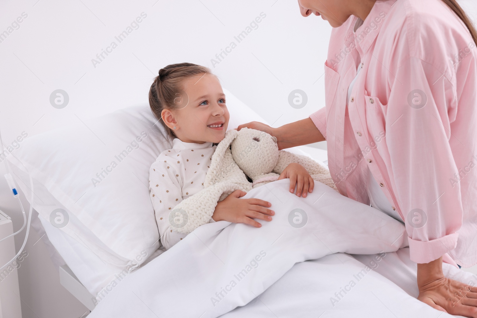 Photo of Mother and her little daughter on bed in hospital