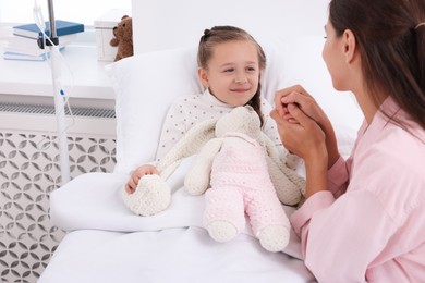 Photo of Mother and her little daughter on bed in hospital