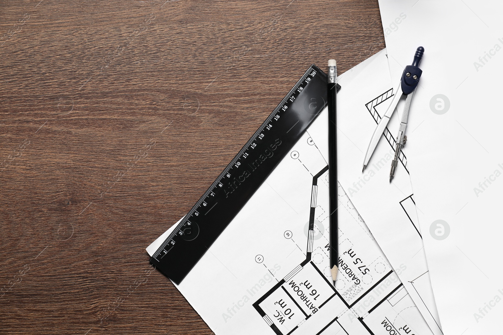 Photo of Different architectural drawings, pencil and dividers on wooden table, flat lay