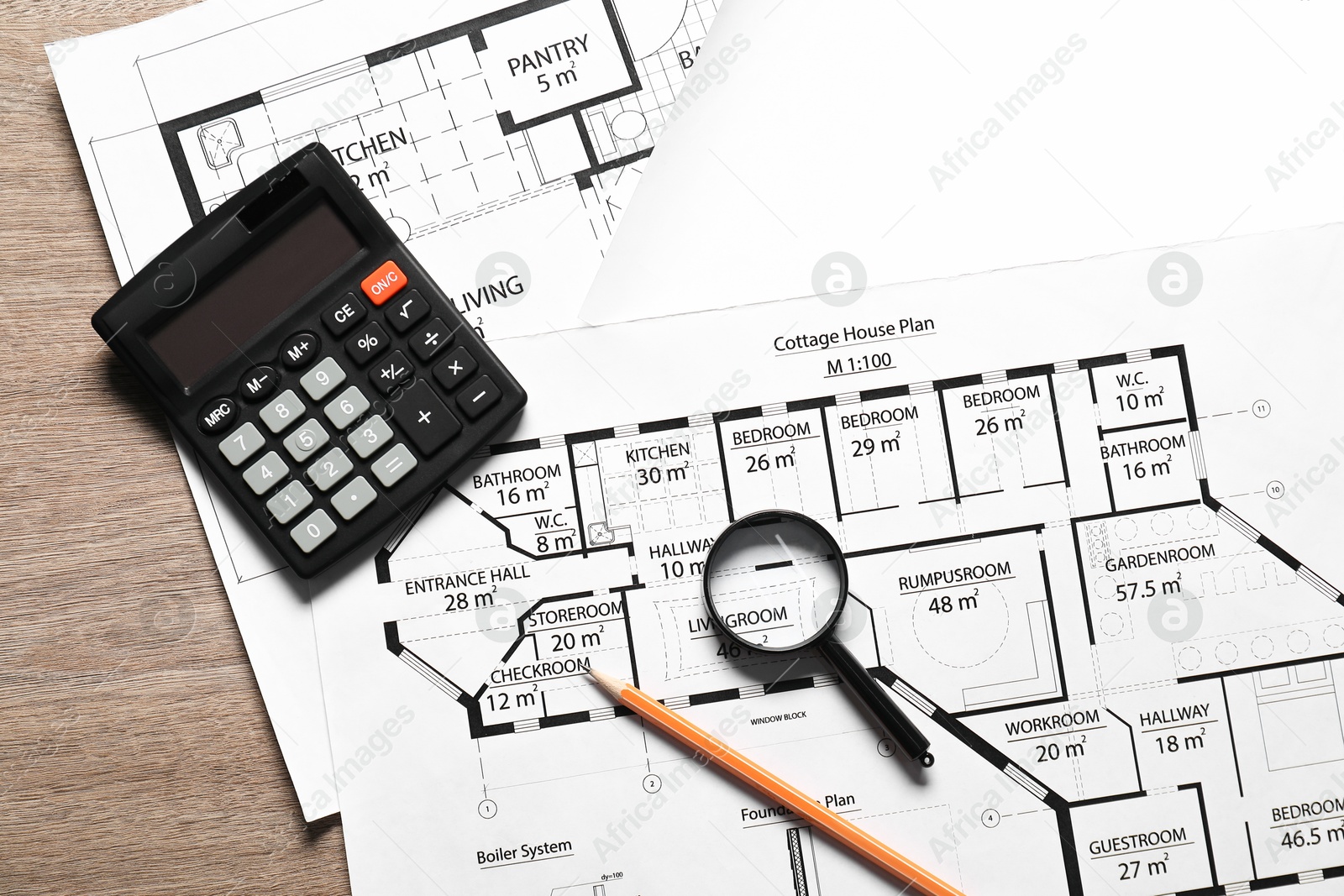 Photo of Different engineering drawings, pencil, calculator and magnifying glass on wooden table, top view