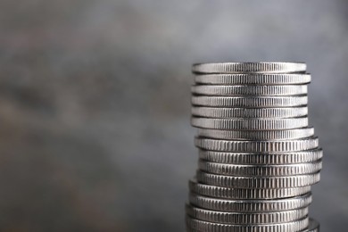 Photo of Stack of coins on blurred grey background, closeup with space for text. Salary concept