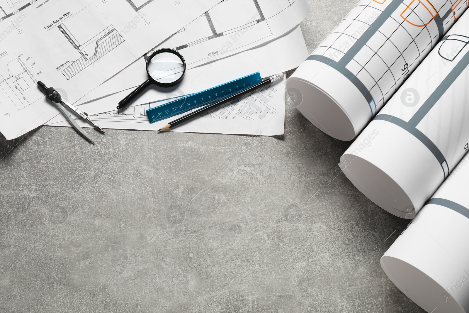 Photo of Different engineering drawings and tools on grey textured table, flat lay. Space for text