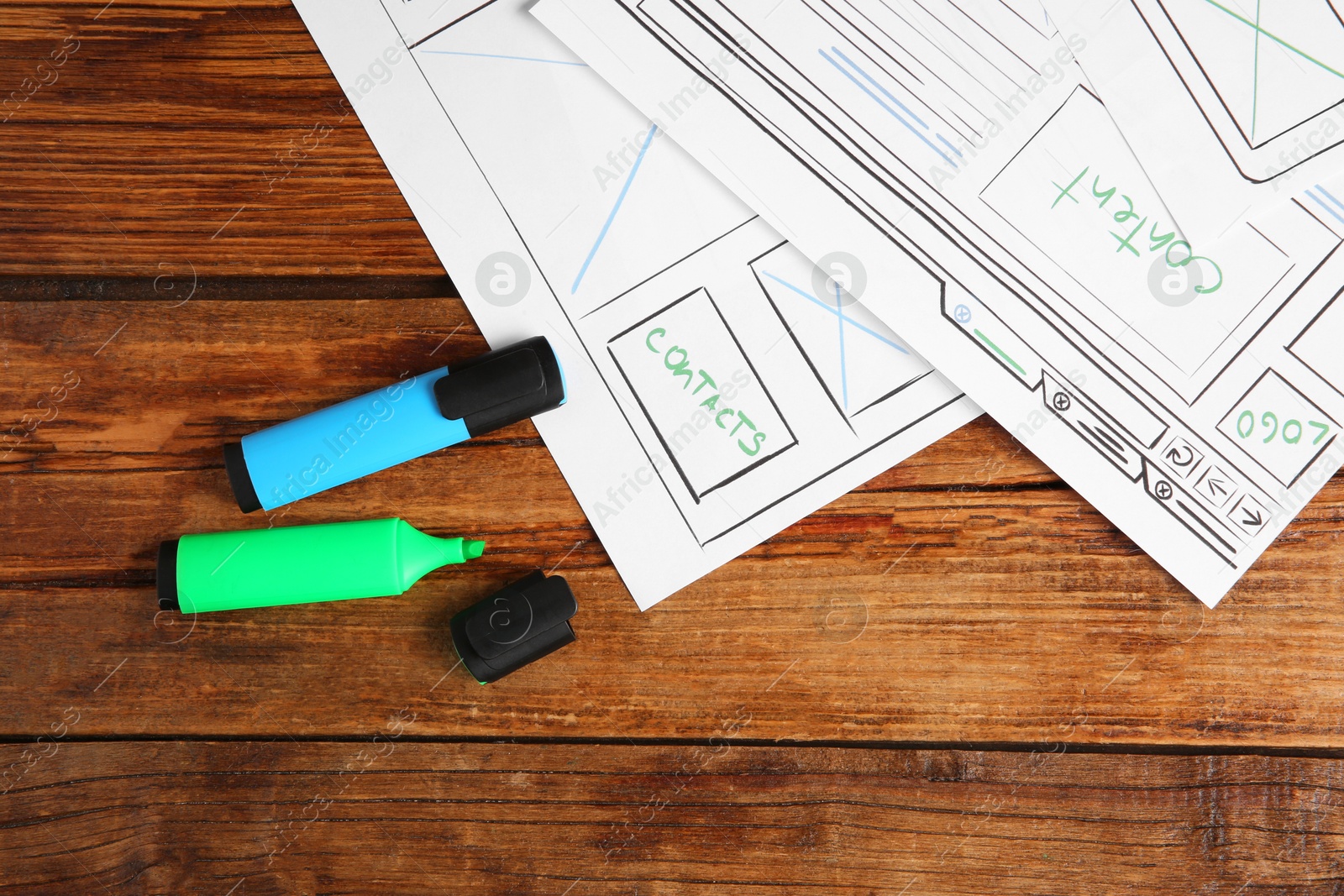 Photo of Developing UI design. Sketches of website wireframes and felt pens on wooden table, top view