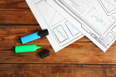 Photo of Developing UI design. Sketches of website wireframes and felt pens on wooden table, top view